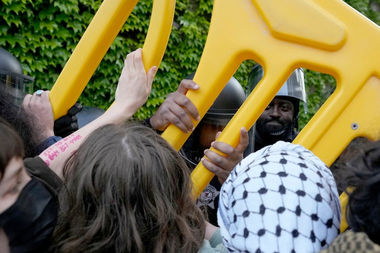 Pro-Palestinian protesters push back as University of Chicago police officers reposition a barricade keeping protesters from the university's quad while the student encampment is dismantled on Tuesday in Chicago.