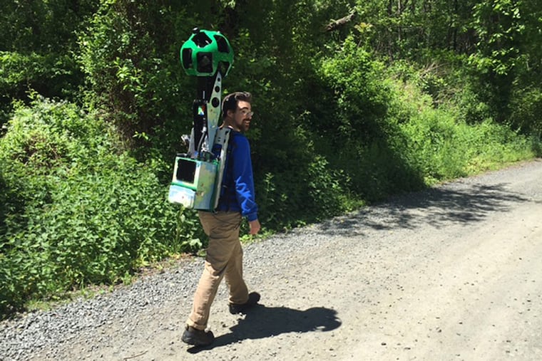 Conor Michaud, of Philadelphia's Parks and Recreation Department, photographs a trail near Belmont Mansion wearing a Google Trekker backpack.