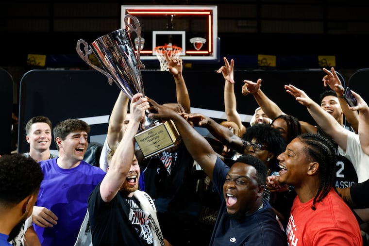 Members of Team TBB hold the 2026 Danny Rumph Classic championship trophy after beating Team Rumph at the Daskalakis Athletic Center on Monday.