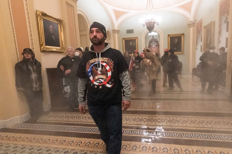 Smoke fills the walkway outside the Senate Chamber as supporters of President Donald Trump are confronted by U.S. Capitol Police officers inside the Capitol.
