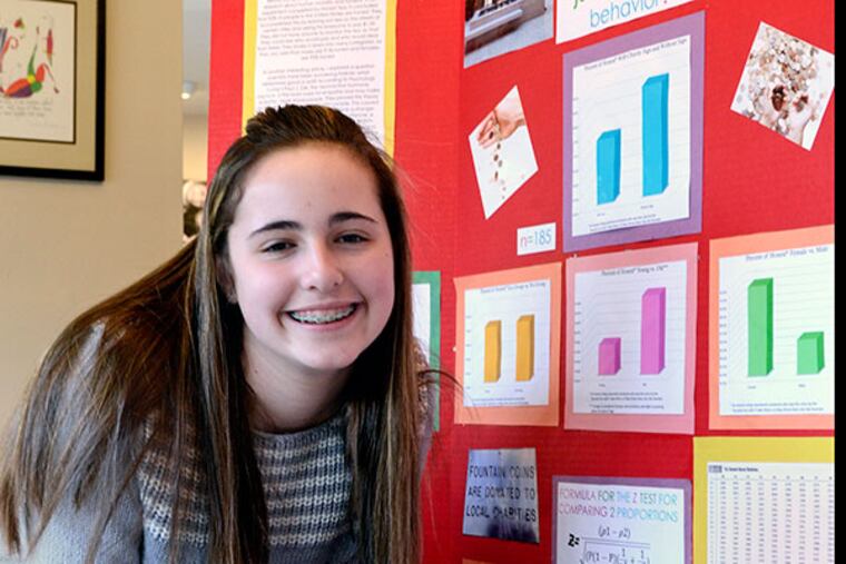 Samantha Sorid, an 8th-grader at Harrington Middle School in Mt. Laurel, poses at home with her first place Coriell Institute Science Fair project. She observed and recorded how people reacted to and acted upon the loose change she placed in public view near one of the fountains inside the Cherry Hill Mall. ( TOM GRALISH / Staff Photographer )