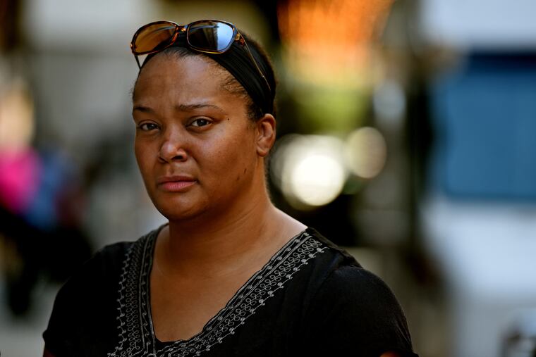 Lyft driver Kenita Jalivay poses outside her vehicle July 9, 2018. The previous night she was trapped in the middle of a shooting scene, and Lyft gave her $5 reimbursement for her trouble and her trauma, having to cancel her last ride. TOM GRALISH / Staff Photographer