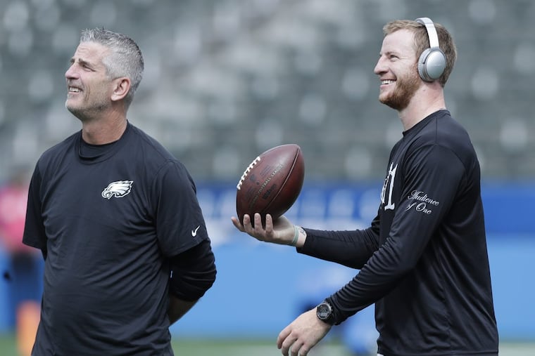 Eagles quarterback Carson Wentz with offensive coordinator Frank Reich during warm-ups before the Eagles play the Los Angeles Chargers on Sunday, October 1, 2017 in Carson, CA. YONG KIM / Staff Photographer