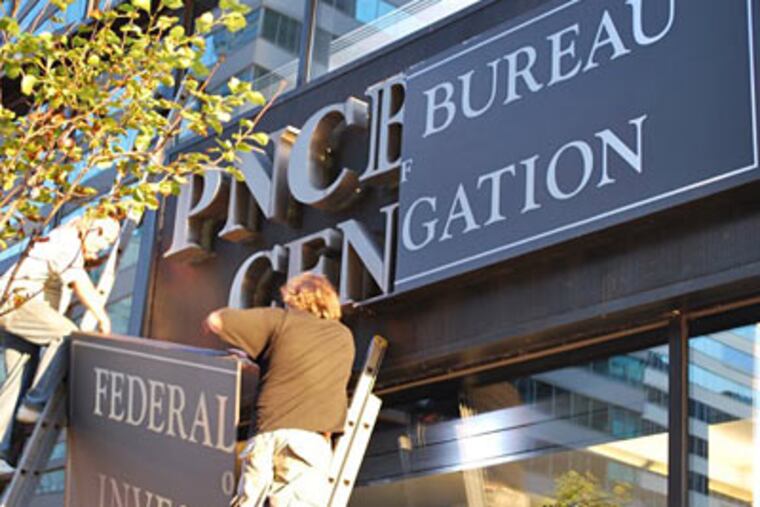 Workers change the sign on the PNC Bank Center for a film crew. ( ROSS IRWIN / Inquirer)
