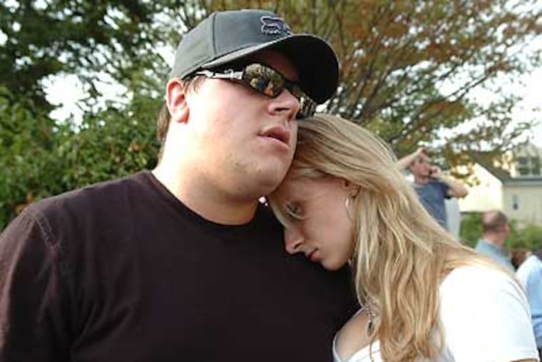 Bill Hotz (left) holds his girlfriend Kamila Serwin as they watch their apartment at the RiverWalk at Millennium burn down. Hotz's cat was trapped inside. (Sharon Gekoski-Kimmel / Inquirer)