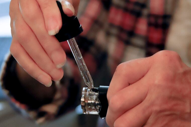 In this Friday, Oct. 4, 2019 photo, a woman loads liquid into her vaping device in Harmony, Pa. On Thursday, Oct. 10, 2019, The Centers for Disease and Prevention on said 219 vaping-related illnesses in the U.S. were reported in the past week. The number continues to rise, now reaching about 1,300 cases and at least 26 deaths.