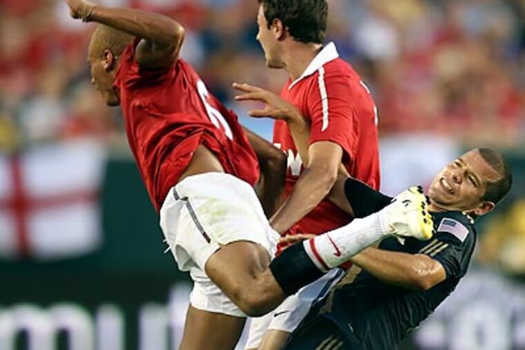 Alejandro Moreno is kicked by Manchester United's Web Brown during the first half. (Steven M. Falk / Staff Photographer)