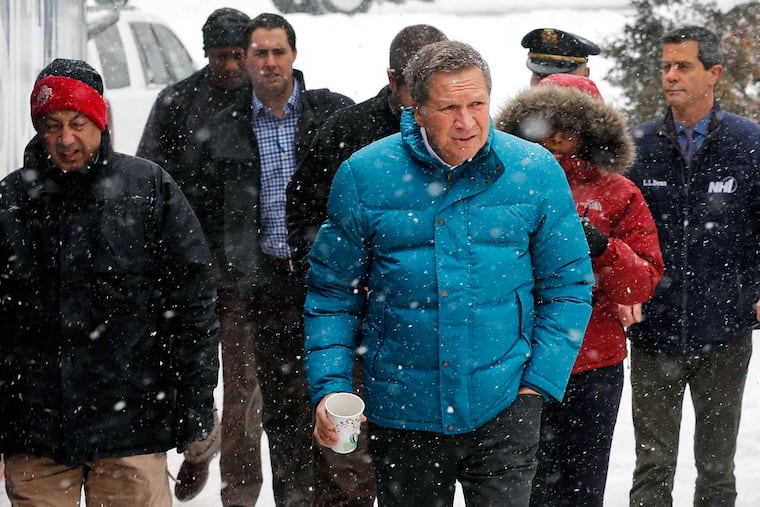 Snow falls as Republican presidential candidate John Kasich arrives for a campaign stop to discuss alcohol and drug-free programs for the youth Monday, Jan. 18, 2016, in Plymouth, N.H.