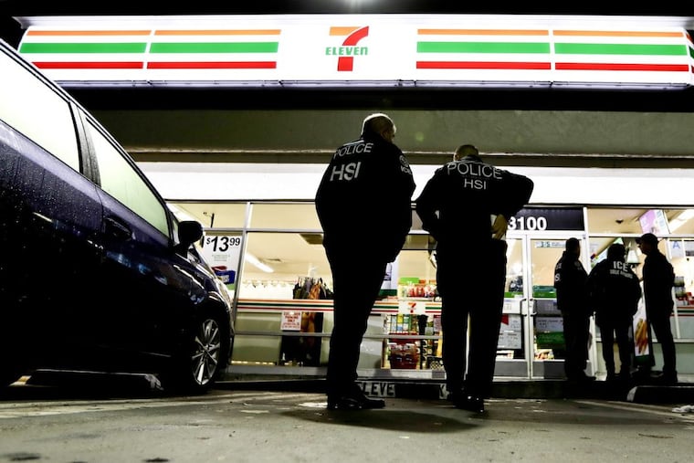U.S. Immigration and Customs Enforcement agents serve an employment audit notice at a 7-Eleven convenience store Wednesday, Jan. 10, 2018, in Los Angeles. Agents said they targeted about 100 7-Eleven stores nationwide Wednesday to open employment audits and interview workers.