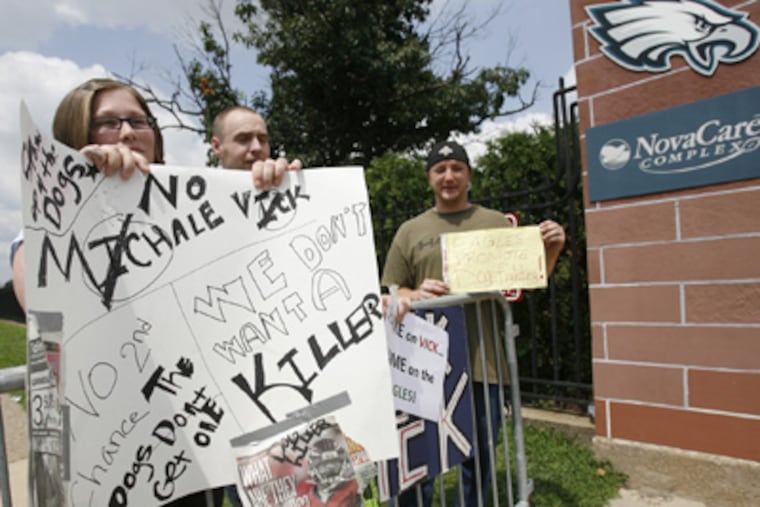 Karrie Geiger, left and husband, Brian, and David Boulden, right, protest the signing of quarterback Michael Vick by the Eagles this morning at the entrance to the NovaCare Complex in South Philadelphia. (Alejandro A. Alvarez / Staff Photographer)