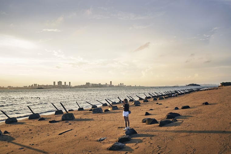 Buildings in Xiamen, on mainland China, stand across the Taiwan Strait from anti-landing barriers on a beach in Kinmen, Taiwan, in 2023. Kinmen is located just off mainland China, and was once the site of fierce fighting.