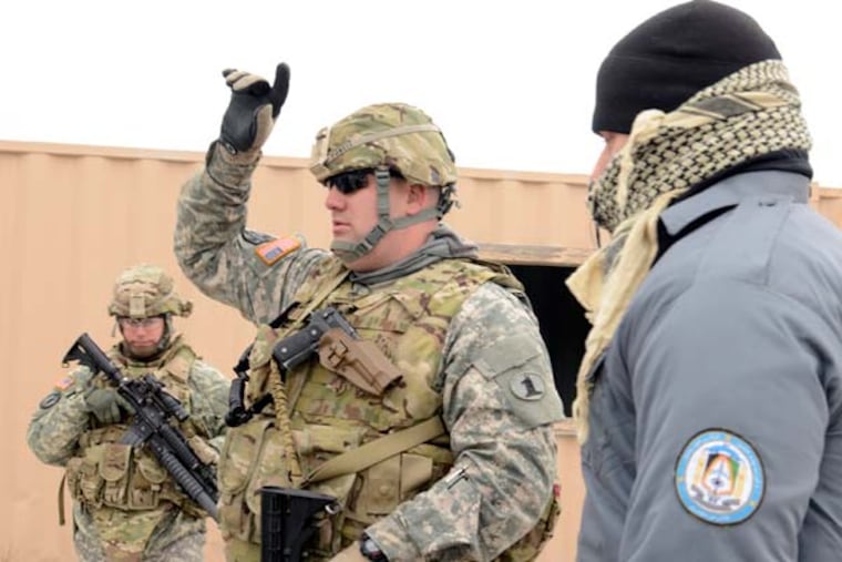 Sgt. Donnie Powell (cq-center) of Newark, Del. talks with workers portraying Afghan police officers during training senario for members of the Delaware Guard’s 153rd Military Police Company at Joint Base McGuire-Dix-Lakehurst February 5, 2013. The MP's are training before heading to mentor the Afghan Police as they try to protect their own country.( TOM GRALISH / Staff Photographer )