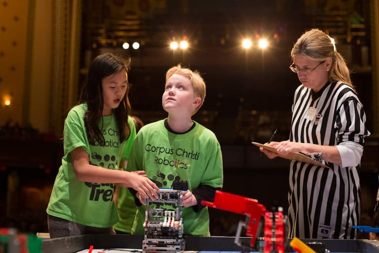 Connor Williamson, 10, looks up at the big screen as he and his partner Mary Eisenhard make minor adjustments to their robot during the Robot Performance competition at the Penn FIRST LEGO League championship at the University of Pennsylvania in Philadelphia, Saturday, Feb. 6, 2016.
