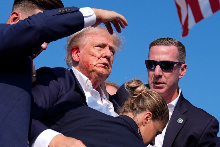 Former President Donald Trump is surrounded by U.S. Secret Service agents as he leaves the stage at a campaign rally on Saturday.