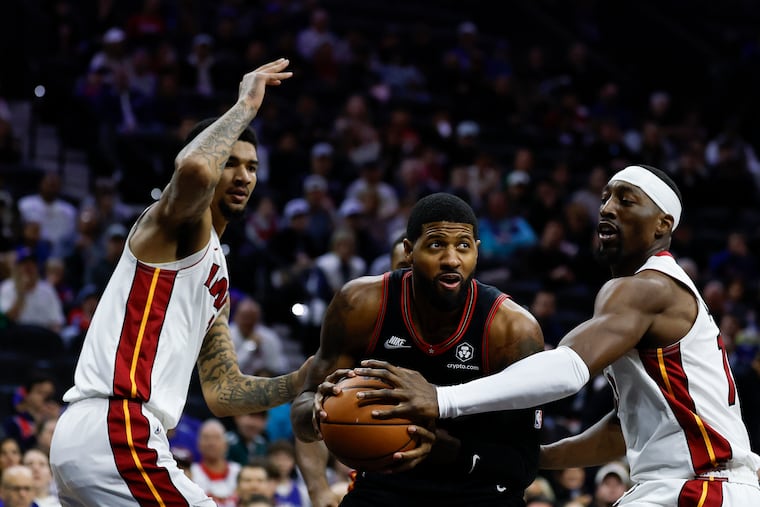 Sixers forward Paul George is guarded by Miami's Kel'el Ware (left) and Bam Adebayo.