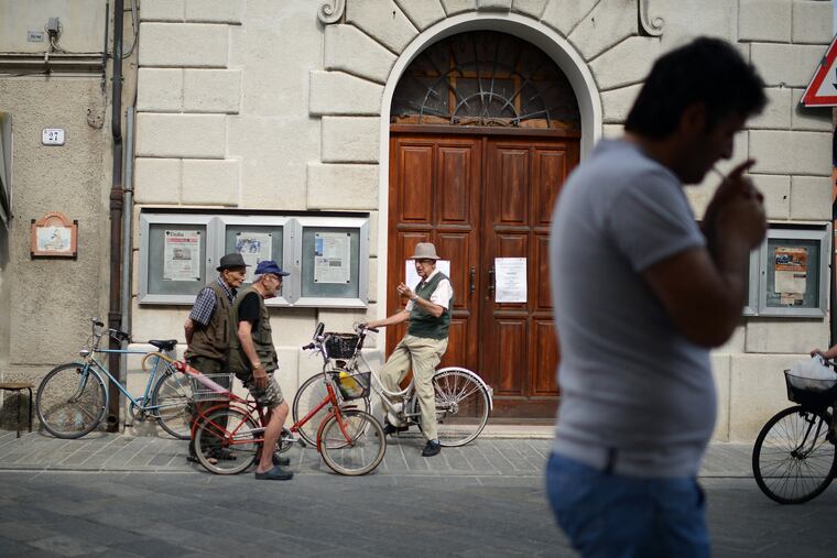 A group of men talk on the main street in Luzzara, Italy on June 26, 2014. ( DAVID MAIALETTI / Staff Photographer )