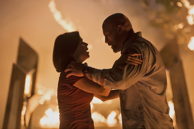 Neve Campbell, left, and Dwayne Johnson in a scene from ';Skyscraper'