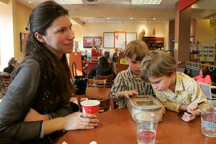 Marie Crosby and her 4-year-old twins, Cullen and Edan, relax in the coffee shop at the Borders store in Chestnut Hill. The longtime fixture at the top of Germantown Avenue attracted lots of bargain hunters on the last day it was open for business.