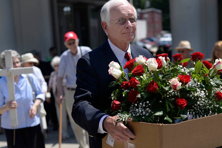David Walsh, 70, walks with a box of roses to the unmarked grave of the 47 fetuses found in Kermit Gosnell's West Philadelphia abortion clinic, during a memorial service on June 10, 2015, at Laurel Hill Cemetery in Philadelphia, Pa. ( BEN MIKESELL / Staff Photographer )