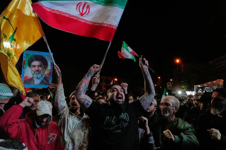 Pro-government demonstrators chant slogans as they hold Iranian flags and a poster of the Supreme Leader Ayatollah Mojtaba Khamenei in a gathering after announcement of a two-week ceasefire in the war with the United States and Israel, at the Enqelab-e-Eslami, or Islamic Revolution, Square, in Tehran, Iran, Wednesday, April 8, 2026.