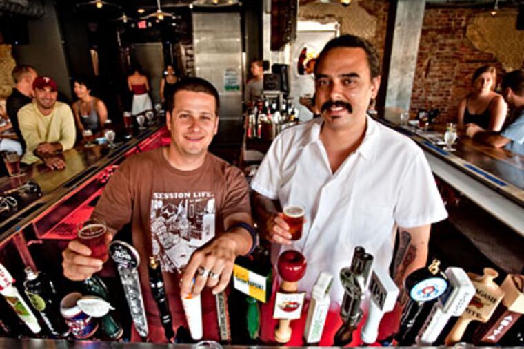 Manager Adam Ritter (left), chef Michael N. Thomas at Kraftwork, which has 25 taps for a changing lineup of craft beers. The place is handsomely decorated with repurposed industrial artifacts. (DAVID M WARREN / Staff Photographer)