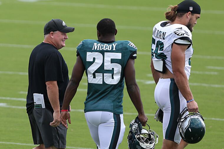 Eagles head coach Chip Kelly talks with running back LeSean McCoy as linebacker Bryan Braman stands near. (David Maialetti/Staff Photographer)
