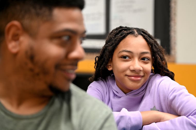 Science Leadership Academy Middle School sixth grader Aubrey Pearson waits with her father, Abdul Pearson, for their meeting with teachers during interim conferences day Wednesday Oct. 11, 2023. The school has moved to "grading for equity," a process where kids are graded differently - not penalized for late assignments or not understanding a concept the first time.