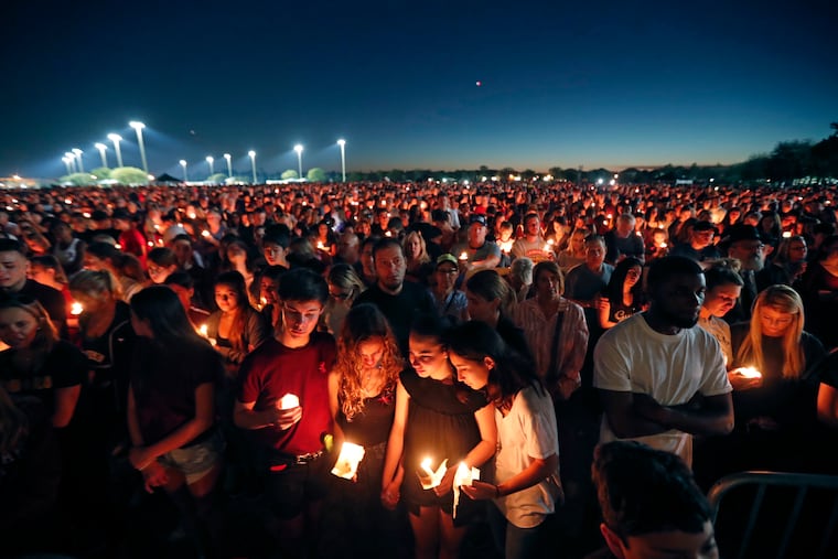 People attend a candlelight vigil for the victims of the shooting at Marjory Stoneman Douglas High School in Parkland, Fla., on Feb. 15, 2018.