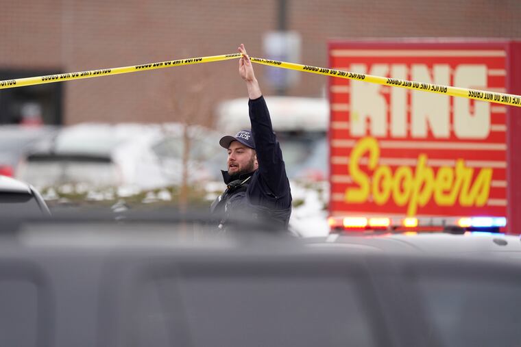 Police work on the scene outside a King Soopers grocery store where a shooting took place Monday in Boulder, Colo.