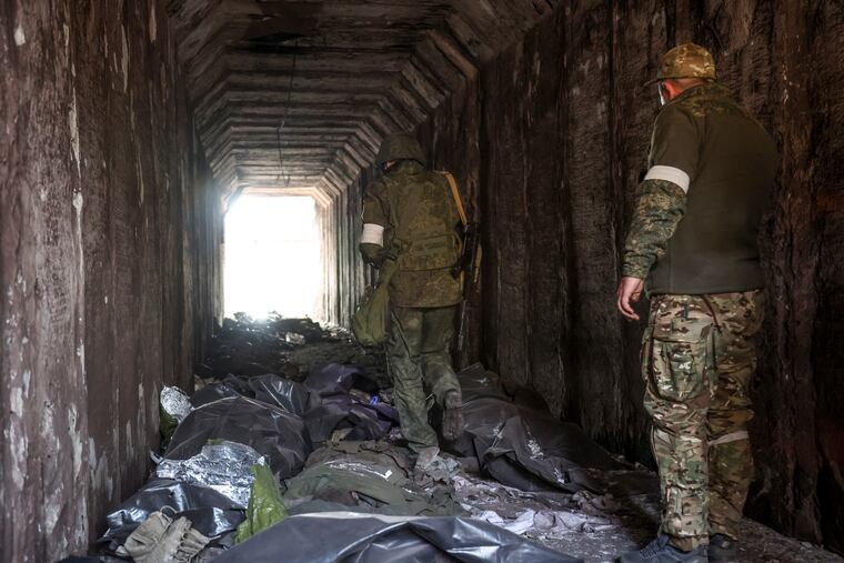 Servicemen of the Donetsk People's Republic militia looking at bodies of Ukrainian soldiers placed in plastic bags in a tunnel, part of the Illich Iron & Steel Works Metallurgical Plant, the second-largest metallurgical enterprise in Ukraine, in an area controlled by Russian-backed separatist forces in Mariupol, Ukraine, on Monday.