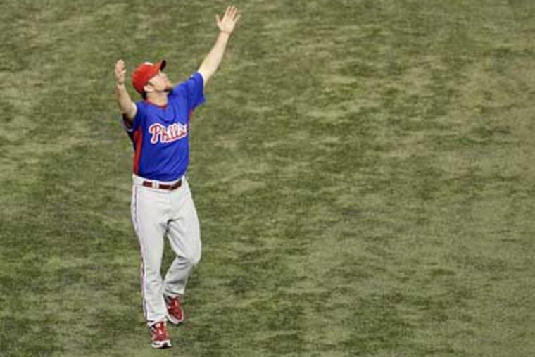 Brad Lidge throws his arms up as a ball sails over his head during Phillies practice at Tropicana Field on Tuesday. (David Maialetti / Staff Photographer)