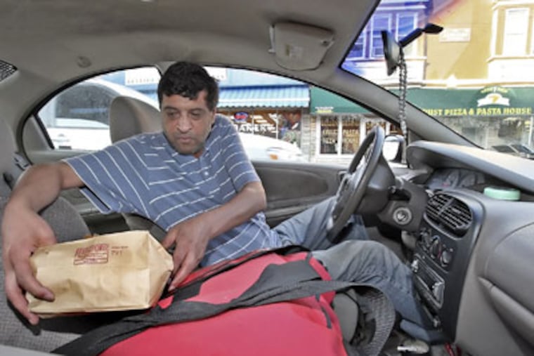 Pizza deliveryman Imad, who was robbed eleven times in ten years, gets ready to leave the Golden Crest for a delivery. (Steven M. Falk / Staff Photographer )