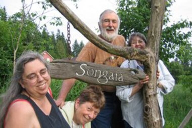 At the entrance to their community are members Karla Luback (left), Nancy and Fred Lanpear, and Dorothy Fulton. About 30 share cooking, cleanup, yard work.