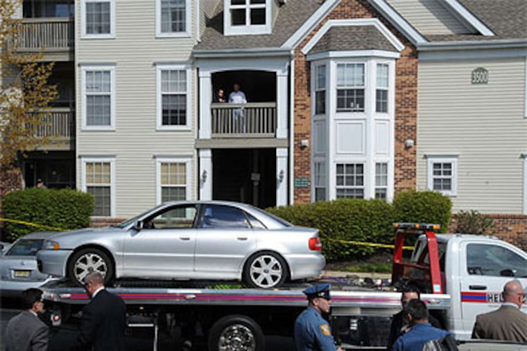 Investigators comb the area near Dr. Payman Houshmandpour's home in Voorhees, N.J., where authorities say he was killed by a former colleague. (Clem Murray / Staff Photographer)