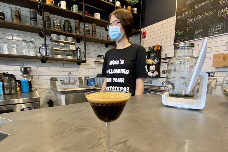 Barista Mel Osborn at the counter of Stomping Grounds Cafe with a double espresso.
