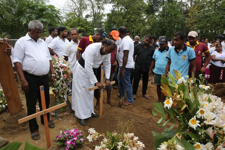 Father Niroshan Perera places a cross during the funeral service of Dhami Brandy, 13, who was killed during Easter Sunday's bomb blast at St. Sebastian Church, in Negombo, Sri Lanka Thursday, April 25, 2019.