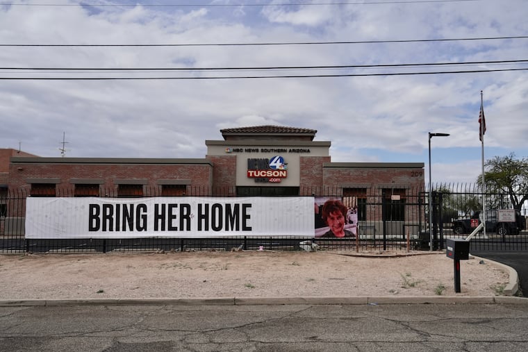 A banner reading "Bring her home" hangs on a fence outside of the KVOA news station in Tucson, Ariz., on Friday, Feb. 13, 2026.