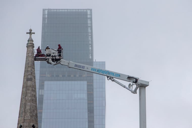 A work crew adds netting to the steeple at Arch Street United Methodist Church during Monday's cold, snow, and sleet.