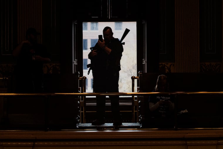 An armed militia member waits inside the Michigan Senate chamber at the Capitol building during the "American Patriot Rally on Capitol Lawn" protest in Lansing, Mich., on April 30.