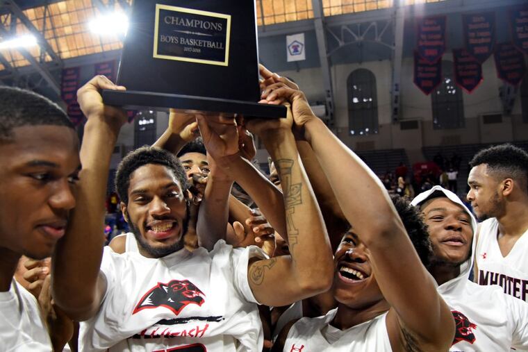 With Amear Johnson holding the trophy, the Imhotep Panthers celebrate their winning the Public League Boys' Basketball Championship against Martin Luther King, 66-37, at the Palestra February 25, 2018.
