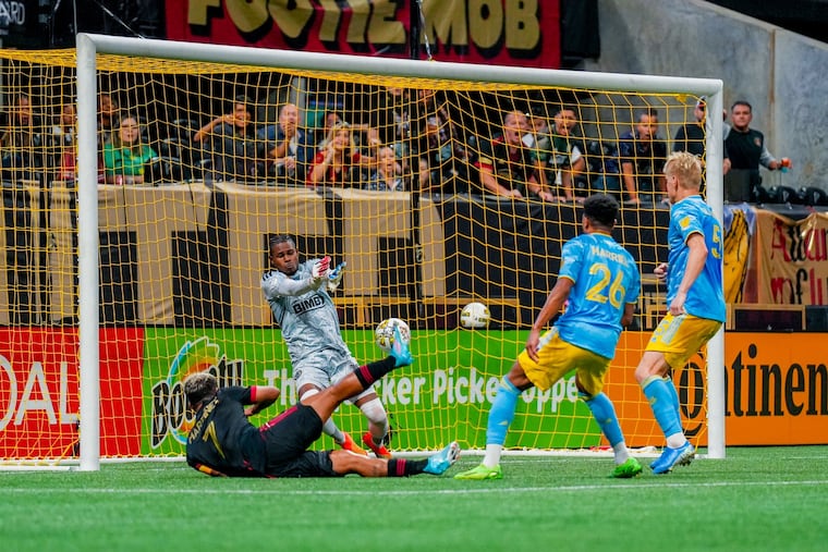 Andre Blake (center) made five saves in the Union's scoreless tie in Atlanta, including this diving stop on the goal line against Atlanta United's Josef Martínez (left) in second-half stoppage time.