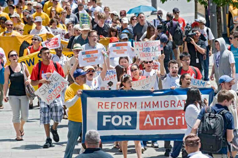 Protesters urging immigration reform in the rally, called "From Philly to Phoenix," march on the sidewalk on Market Street near 6th, heading toward the Visitors Center yesterday.