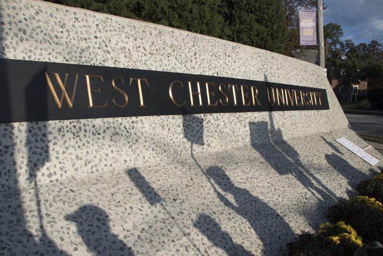 The shadows of striking faculty of West Chester University march across the schools large sign October 19, 2016 as they and the rest of the professors in the state’s higher education system go on strike.