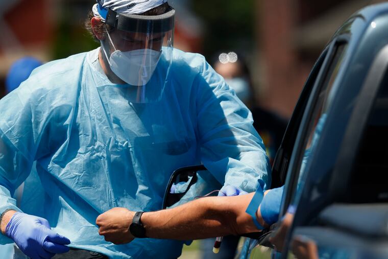 A health worker draws blood for COVID-19 antibody testing in Dearborn, Mich.
