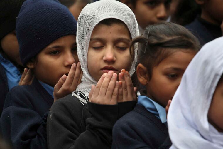 Students in Lahore, Pakistan, pray for the massacre victims. Most schools were closed for a period of national mourning, but groups of students and teachers gathered for prayers.
