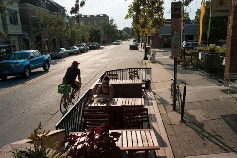 A Collingswood woman reads in the new parklet, which will be positioned at spots along Haddon Avenue. (ANDREW RENNEISEN / Staff Photographer)