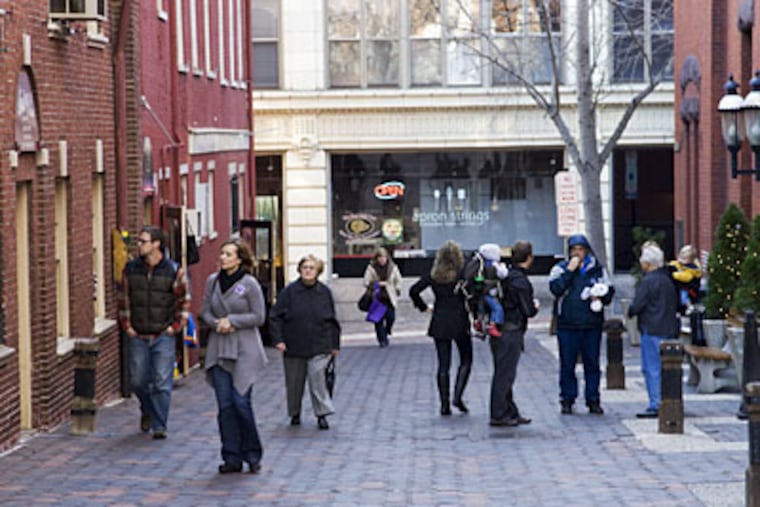 Pedestrians pass Central Market. (TOM MIHALEK / For the Inquirer)
