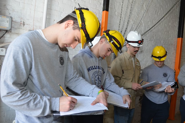 Seniors at Williamson College of the Trades often serve as mentors to underclassmen, sharing their knowledge. The power plant technology senior in the brown shirt, is instructing underclassmen in the college’s power plant.