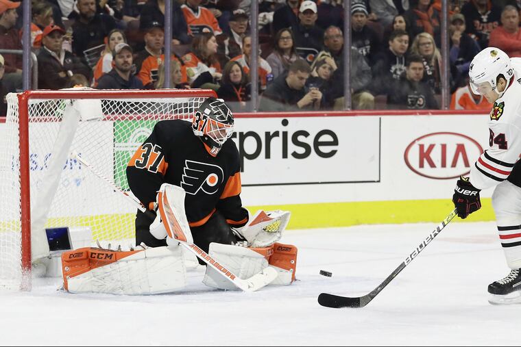 Flyers goaltender Brian Elliott stops Chicago's David Kampf en route to his first shutout of the season Saturday, a 4-0 win at the Wells Fargo Center.