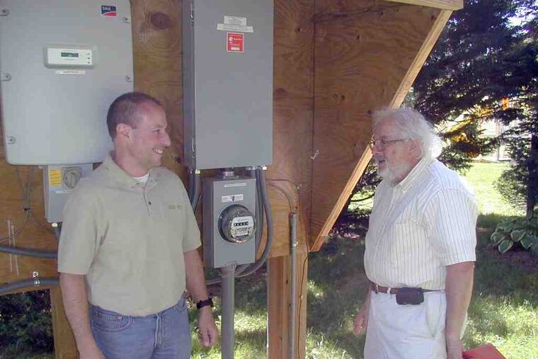 Guy Jacquet (left), the owner of Solar Pro, installed the system belonging to Edward Frankel. The meter measures the output from Frankel's solar array.